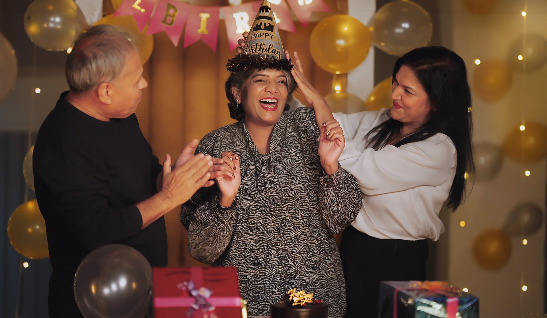 Indian smiling older aged cute male female modern friends dancing on song music at night party making fun at indoor decor house. Happy elder grandpa grandma group having joyful birthday celebrate enjoy together at home