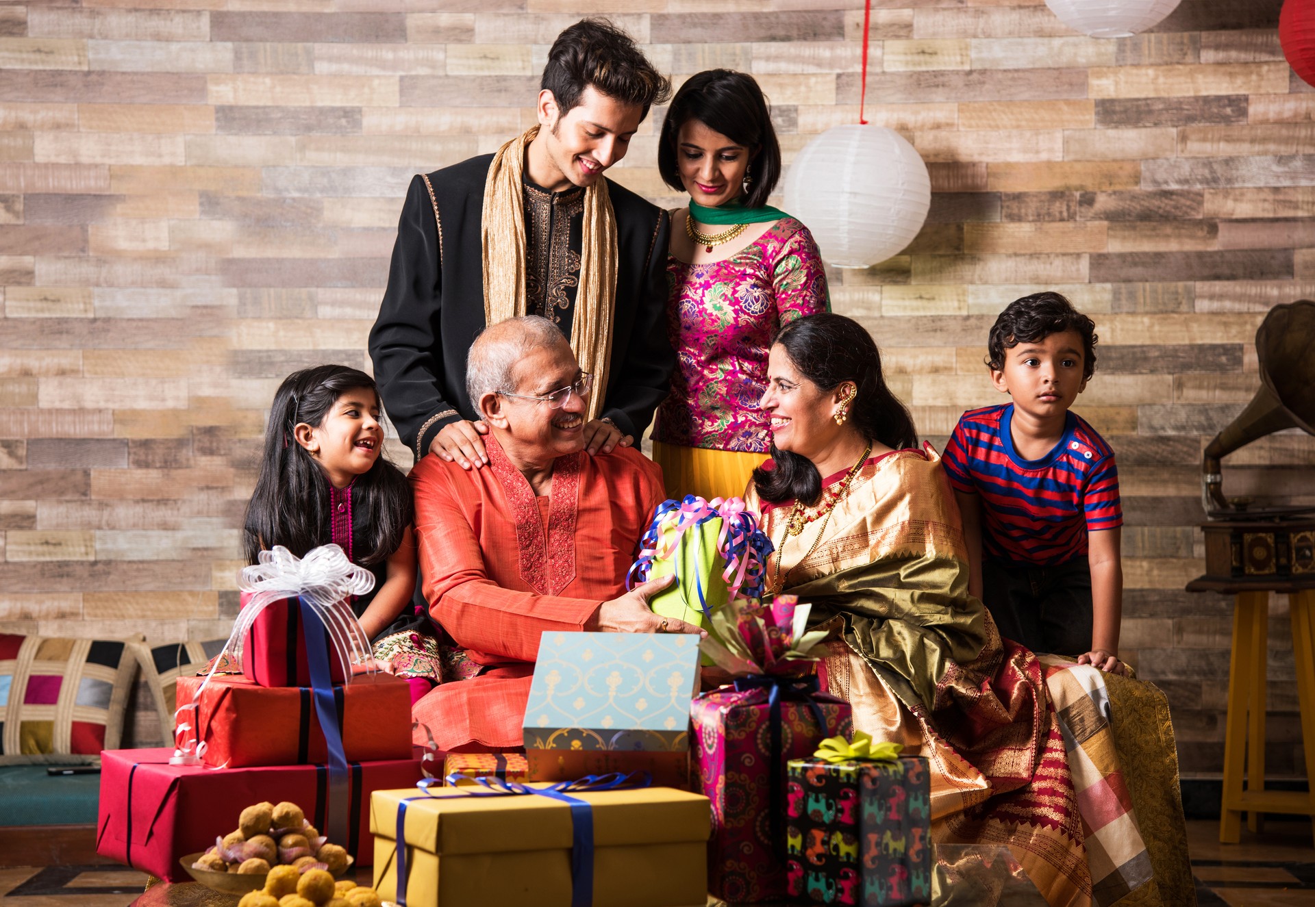 diwali and indian family on sofa enjoying gifts